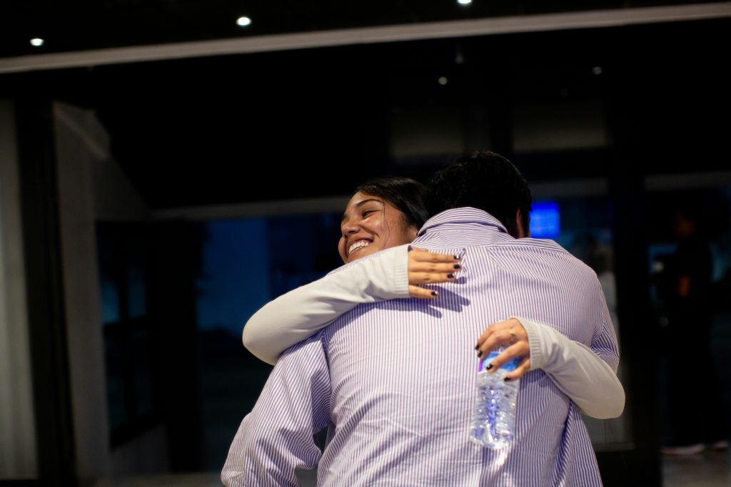 A couple of people that are hugging each other